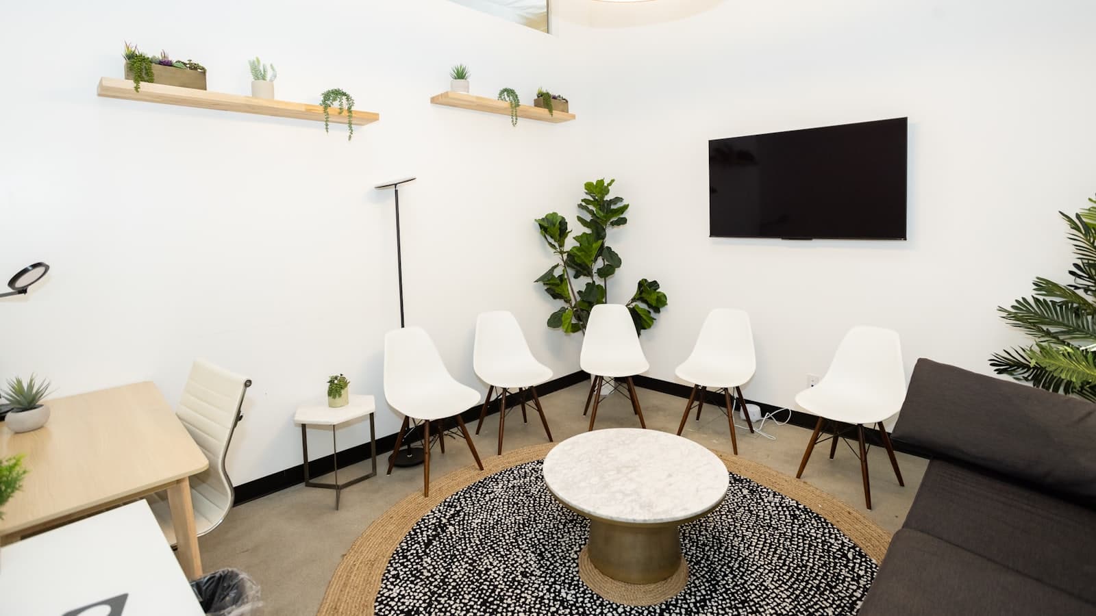 Sala de espera moderna con sillas vacías y plantas
